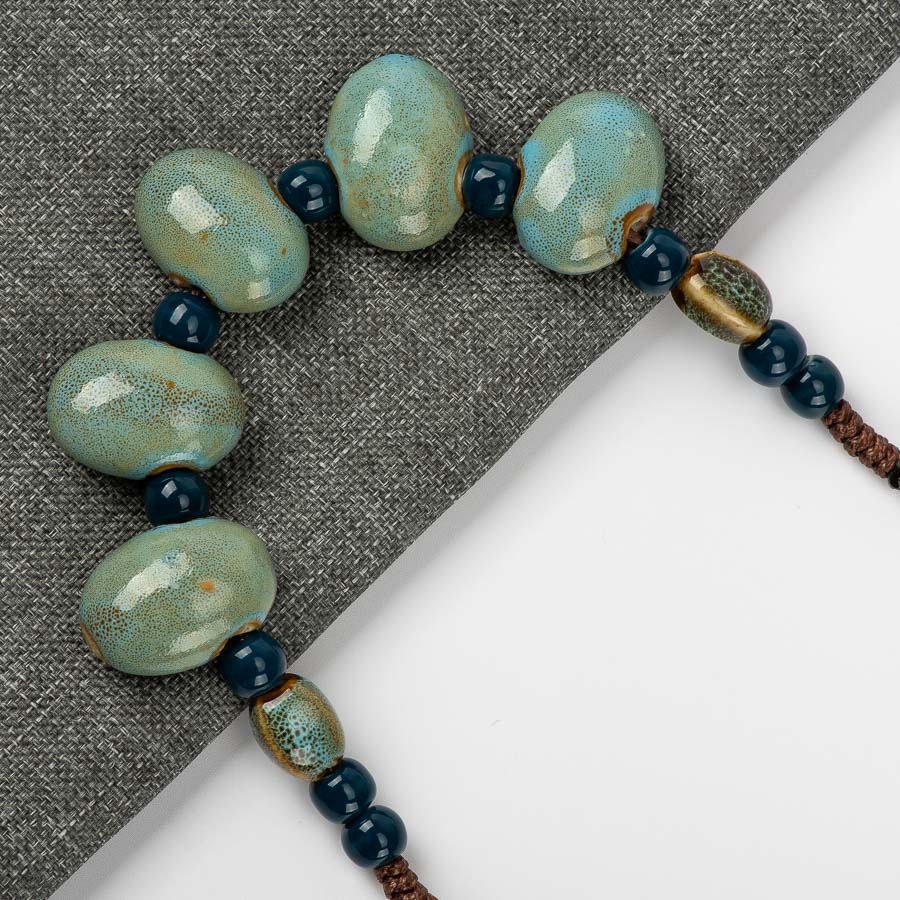 COLLIER DE PERLES EN CÉRAMIQUE EN FORME DE PAVÉ